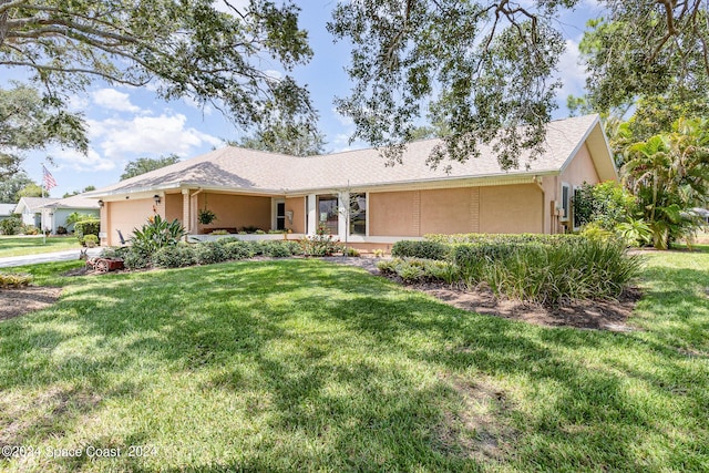 ranch-style house featuring a front yard, an attached garage, and stucco siding