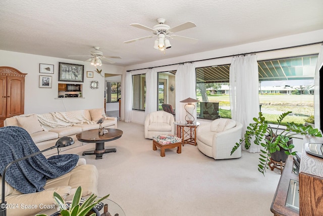 living room with a textured ceiling, a ceiling fan, and carpet flooring