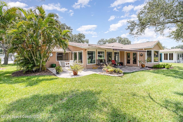 back of property with a patio area, a yard, and stucco siding