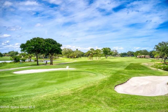 view of home's community with a water view, a lawn, and golf course view