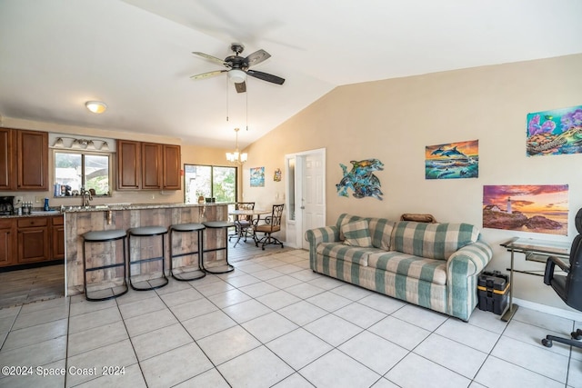 tiled living room with sink, ceiling fan with notable chandelier, and vaulted ceiling