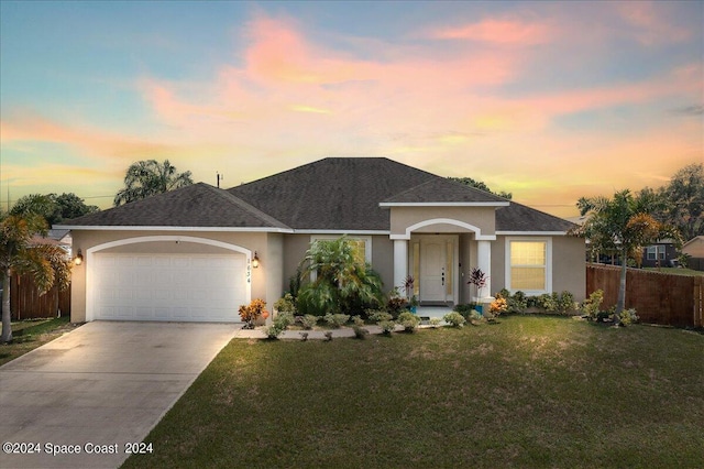 view of front of house featuring a lawn and a garage