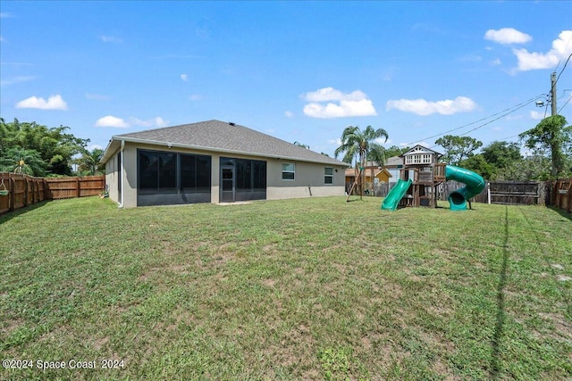 exterior space with a yard, a sunroom, and a playground