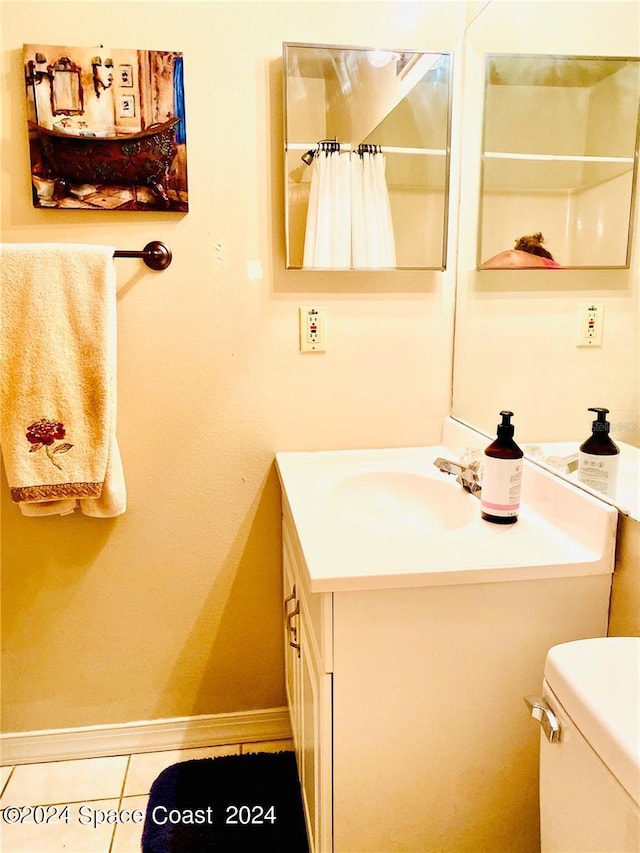 bathroom featuring tile patterned flooring, toilet, and vanity