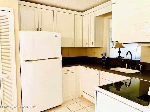 kitchen with sink, white appliances, white cabinetry, and light tile patterned floors