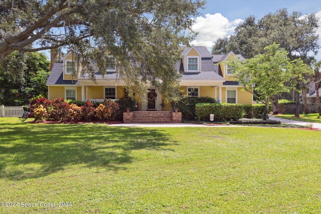 cape cod home with a front lawn