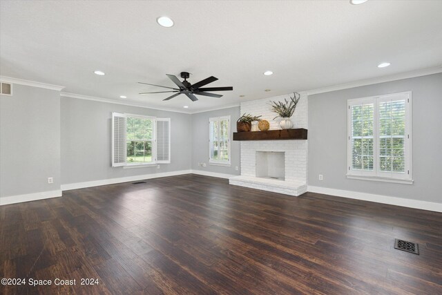 unfurnished living room featuring ceiling fan, plenty of natural light, crown molding, and a brick fireplace