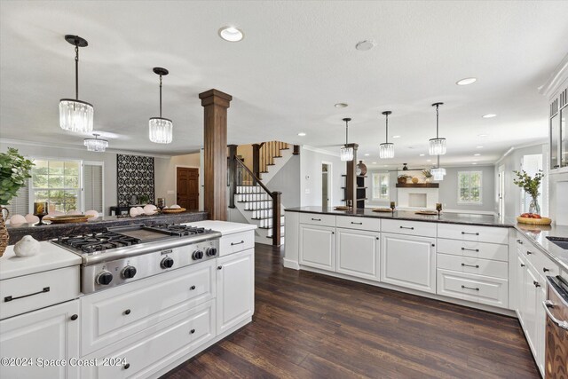 kitchen featuring decorative light fixtures, dark wood-type flooring, white cabinetry, decorative columns, and stainless steel gas stovetop