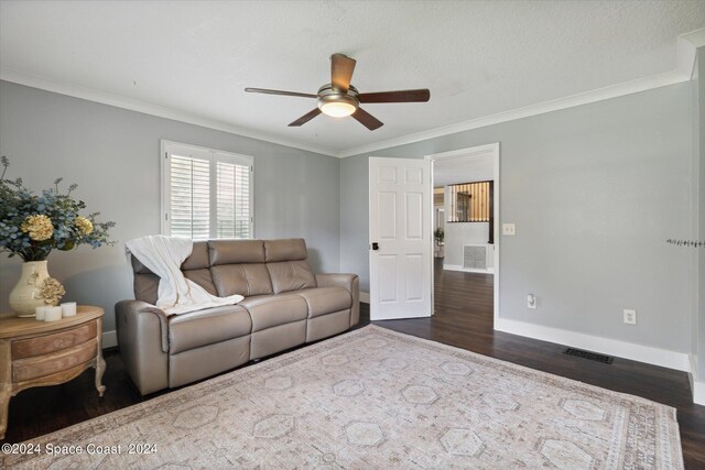 living room with ceiling fan, dark wood-type flooring, and crown molding