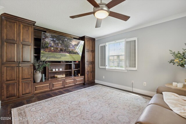 living room featuring ceiling fan, dark hardwood / wood-style floors, crown molding, and a textured ceiling