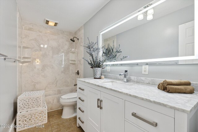 bathroom with toilet, vanity, and tile patterned flooring