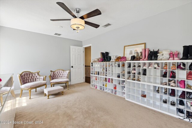 living area with carpet floors and ceiling fan