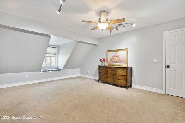 bonus room with ceiling fan, lofted ceiling, and light colored carpet