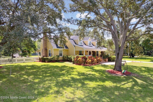 cape cod house featuring a front lawn