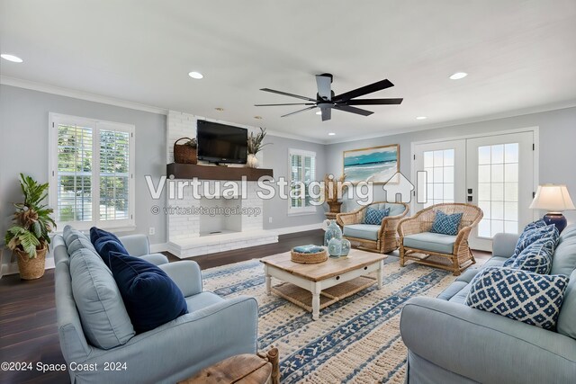 living room featuring wood-type flooring, a brick fireplace, french doors, ceiling fan, and crown molding