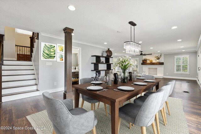 dining room featuring dark hardwood / wood-style flooring, crown molding, and decorative columns