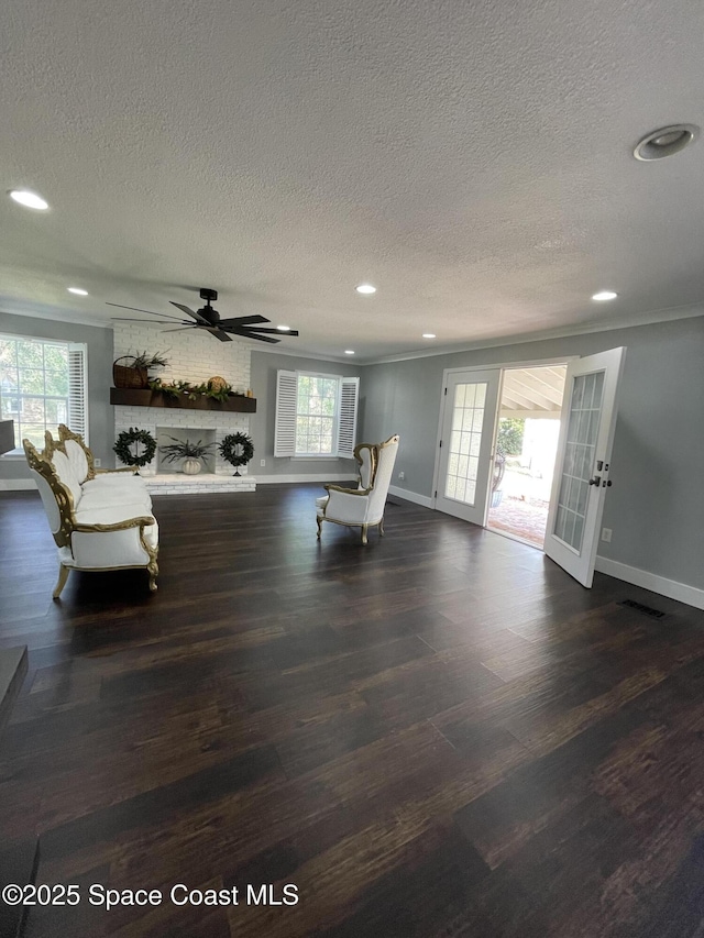 unfurnished living room with ceiling fan, a healthy amount of sunlight, french doors, and a brick fireplace