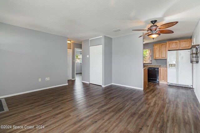 unfurnished living room with dark hardwood / wood-style flooring and ceiling fan