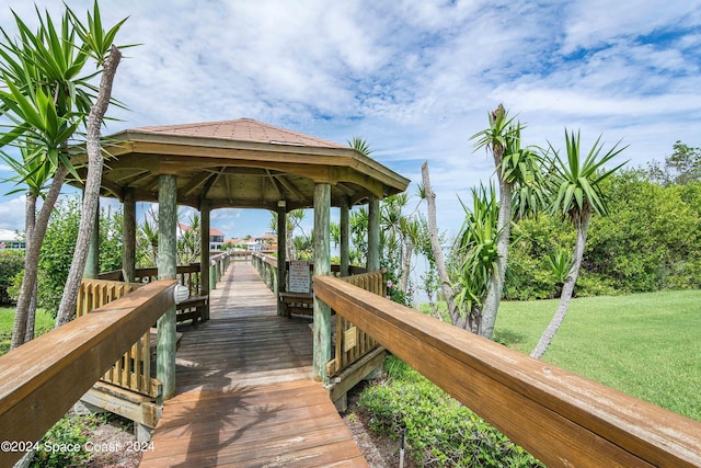 view of dock with a lawn and a gazebo