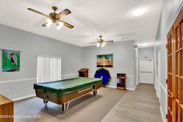 game room with ceiling fan, a textured ceiling, baseboards, and wood finished floors