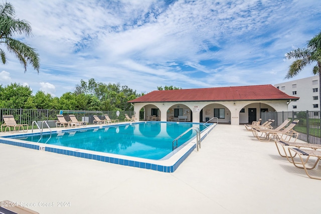 view of pool with a patio area and fence