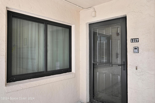 doorway to property featuring stucco siding