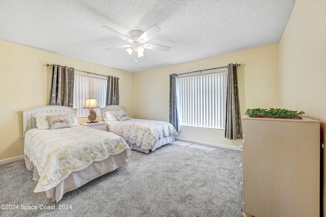 carpeted bedroom featuring a textured ceiling, ceiling fan, and baseboards