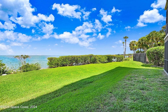 view of yard featuring a water view and fence