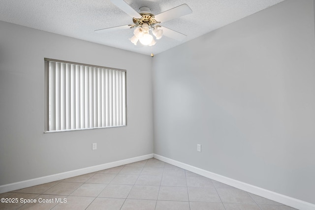 unfurnished room featuring a ceiling fan, light tile patterned flooring, a textured ceiling, and baseboards