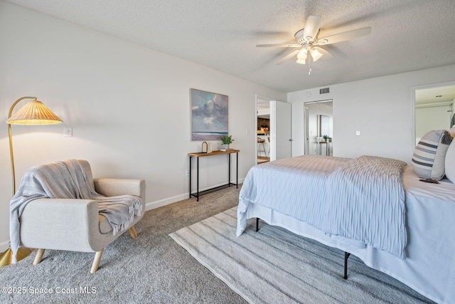 bedroom featuring a textured ceiling, ceiling fan, visible vents, baseboards, and carpet