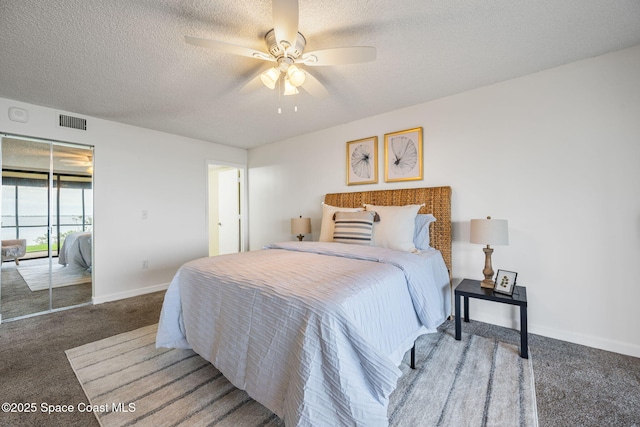 carpeted bedroom featuring a ceiling fan, baseboards, visible vents, and a textured ceiling