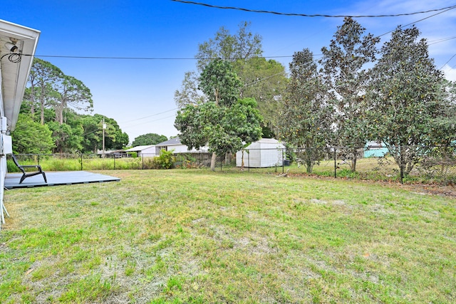 view of yard featuring a storage unit and a wooden deck