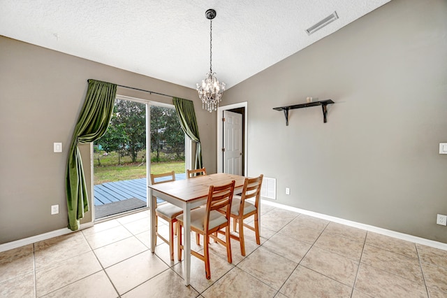 tiled dining space featuring lofted ceiling, a textured ceiling, and a chandelier