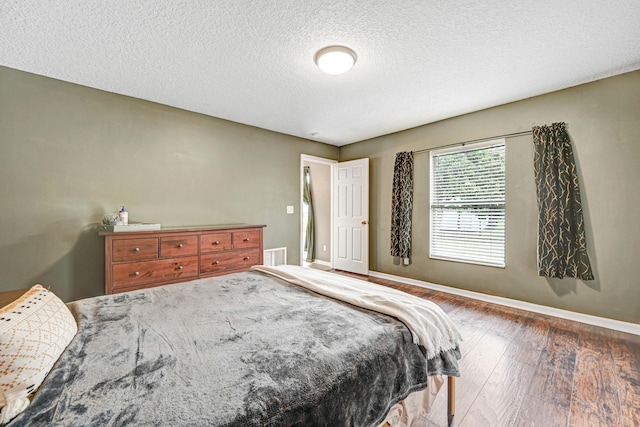 bedroom with wood-type flooring and a textured ceiling