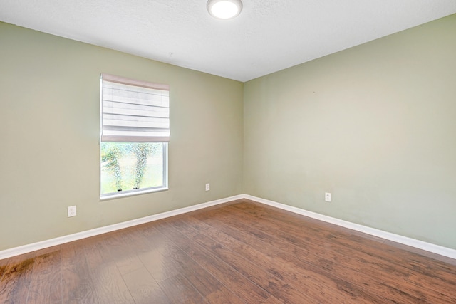 empty room with wood-type flooring and a textured ceiling