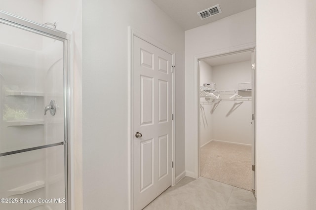 bathroom featuring an enclosed shower and tile patterned floors