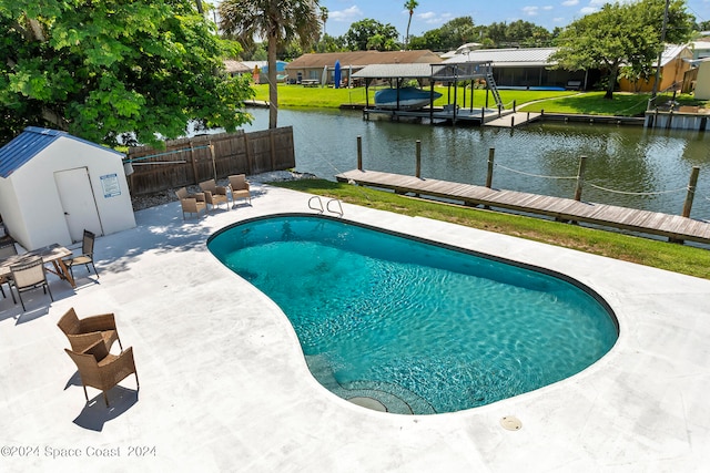 view of pool featuring a patio area, a boat dock, and a lawn