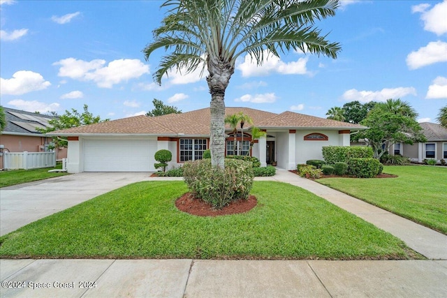 view of front of house with a garage and a front lawn