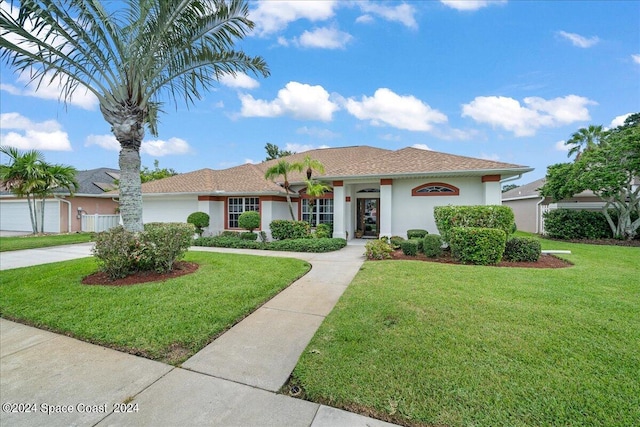 view of front of property featuring a front yard and a garage