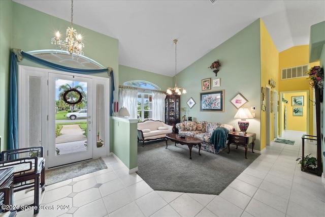 entrance foyer with high vaulted ceiling, light tile patterned floors, visible vents, and a notable chandelier