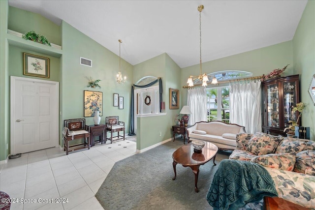 living area with high vaulted ceiling, light tile patterned flooring, a notable chandelier, visible vents, and baseboards