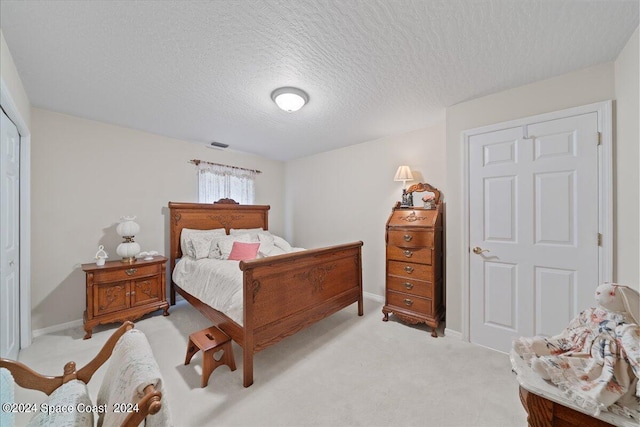 carpeted bedroom with a closet and a textured ceiling