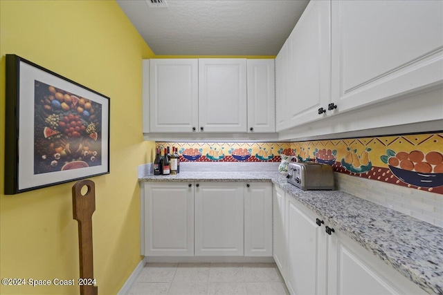 laundry room with a textured ceiling and light tile patterned floors