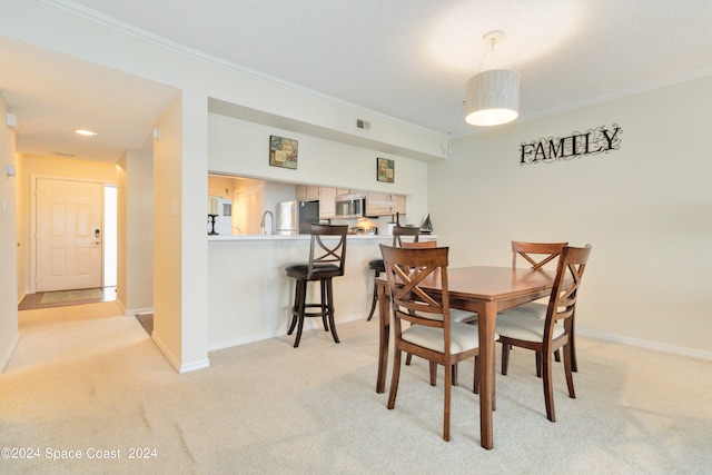 carpeted dining area featuring crown molding