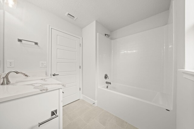 bathroom with vanity, a textured ceiling, and bathing tub / shower combination