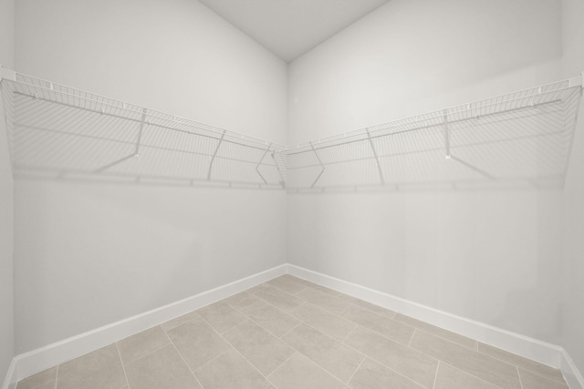 walk in closet with light tile patterned floors