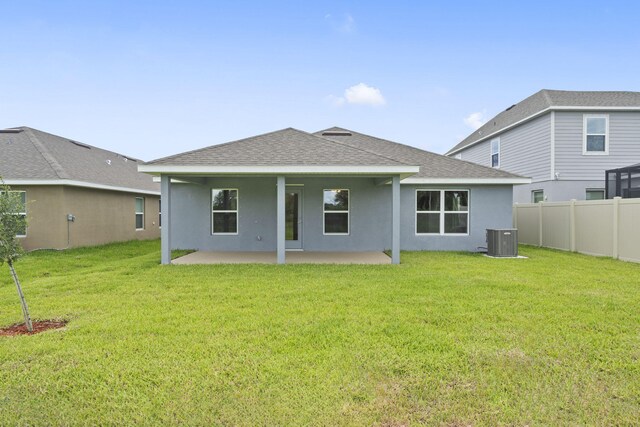 rear view of house featuring central AC unit, a patio area, and a yard