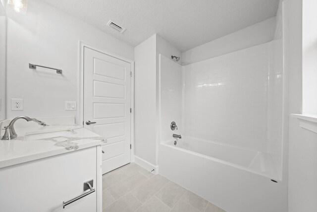 bathroom featuring vanity, washtub / shower combination, and a textured ceiling