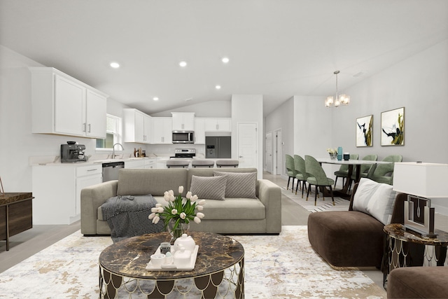 living room with an inviting chandelier and lofted ceiling