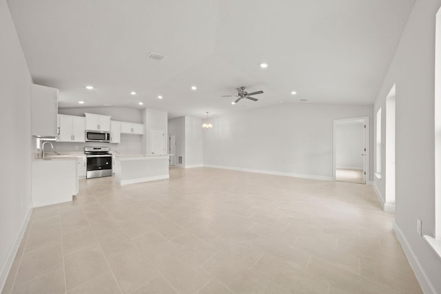 unfurnished living room featuring vaulted ceiling, sink, light tile patterned flooring, and ceiling fan